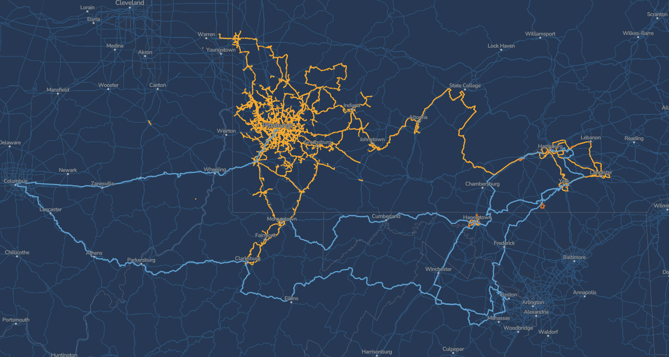 A dark blue map shows two networks: orange lines cluster in the Wheeling, WV area, while blue lines connect Wheeling, Columbus, Pittsburgh, and extend south through West Virginia, crossing various towns and cities.
